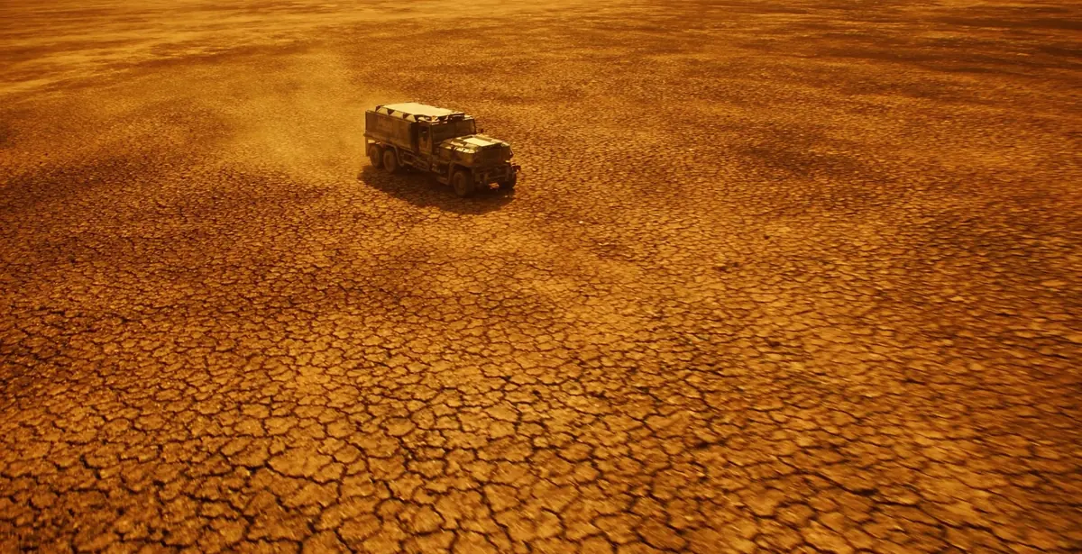 Frame from a Floodgates film: a vehicle crossing cracked desert ground