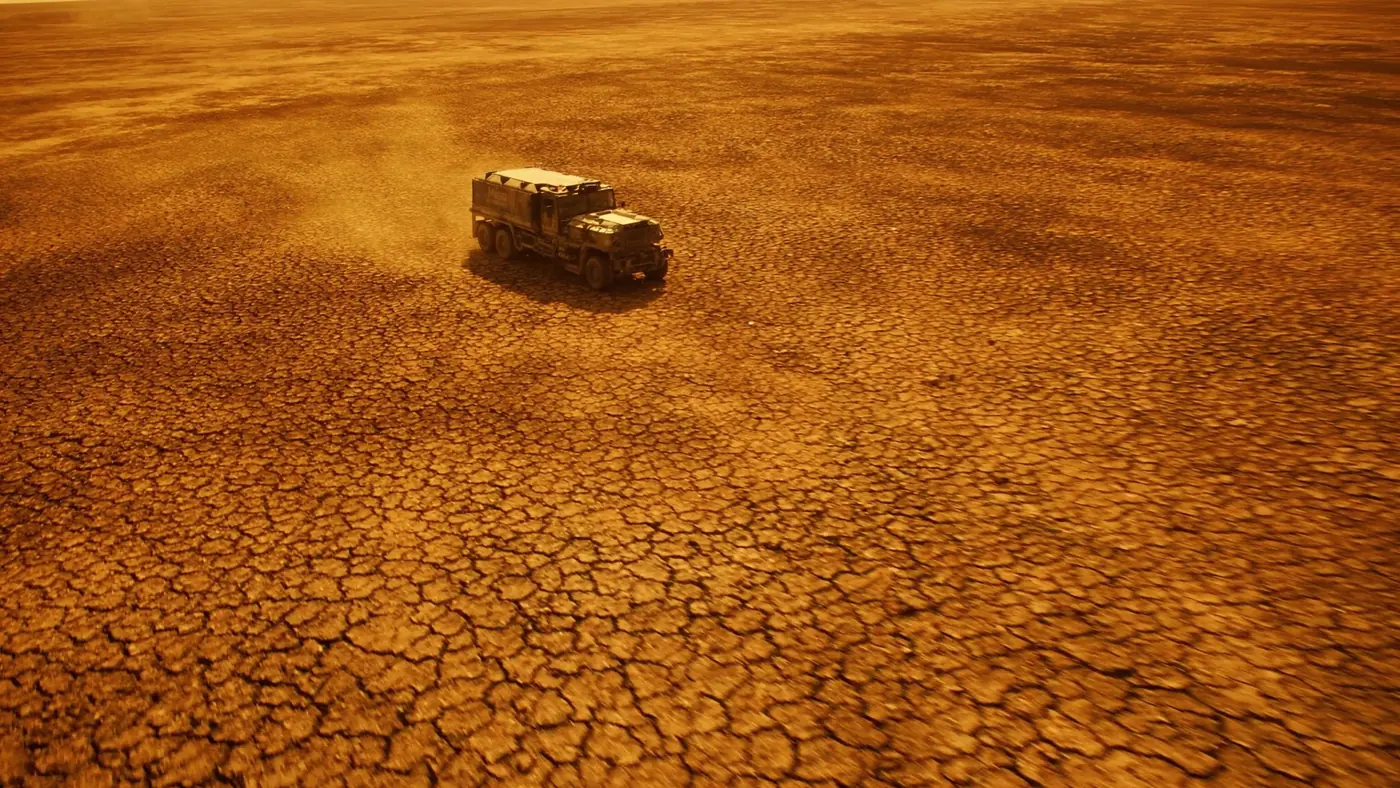 Still from the Floodgates trailer: a lone vehicle crossing cracked desert ground